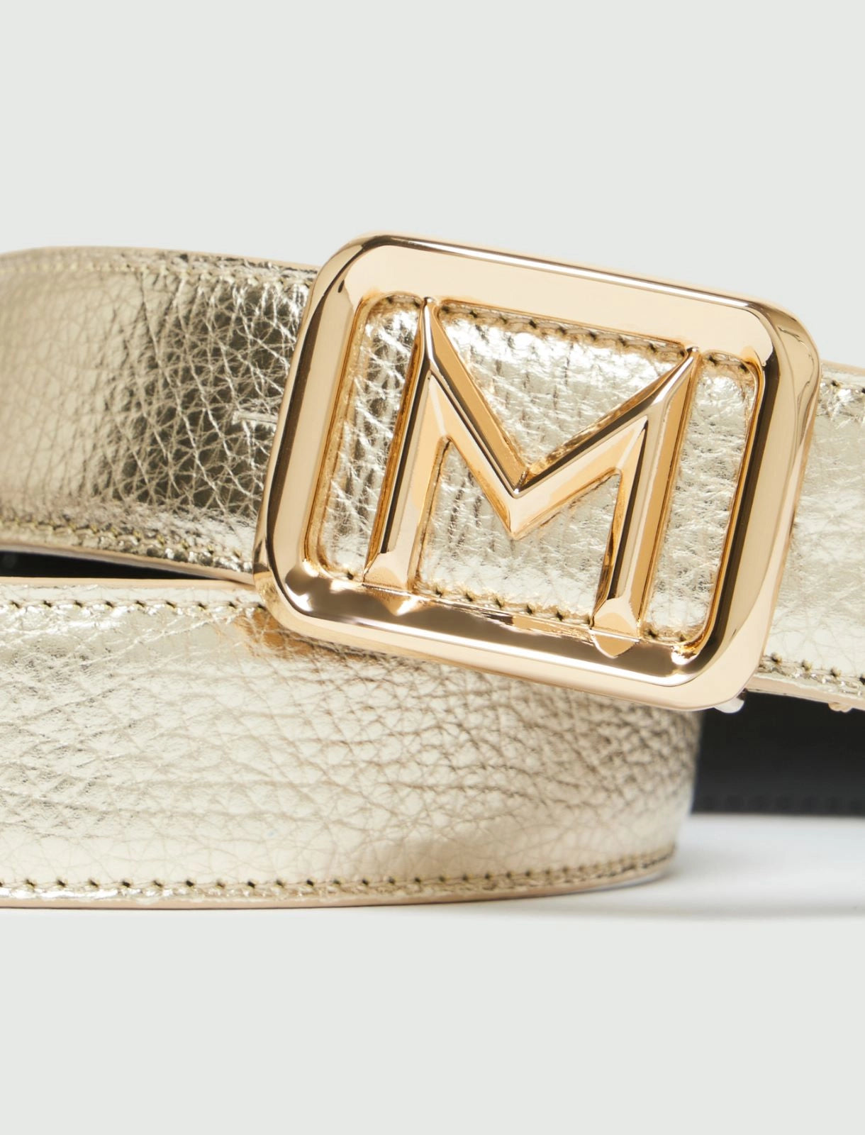 Golden M buckle-adorned belt